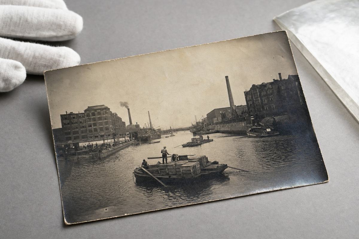 Archival 1906 photo of paired Ford facilities and barge shuttles across the Huron Strait, reproduced on a light table.