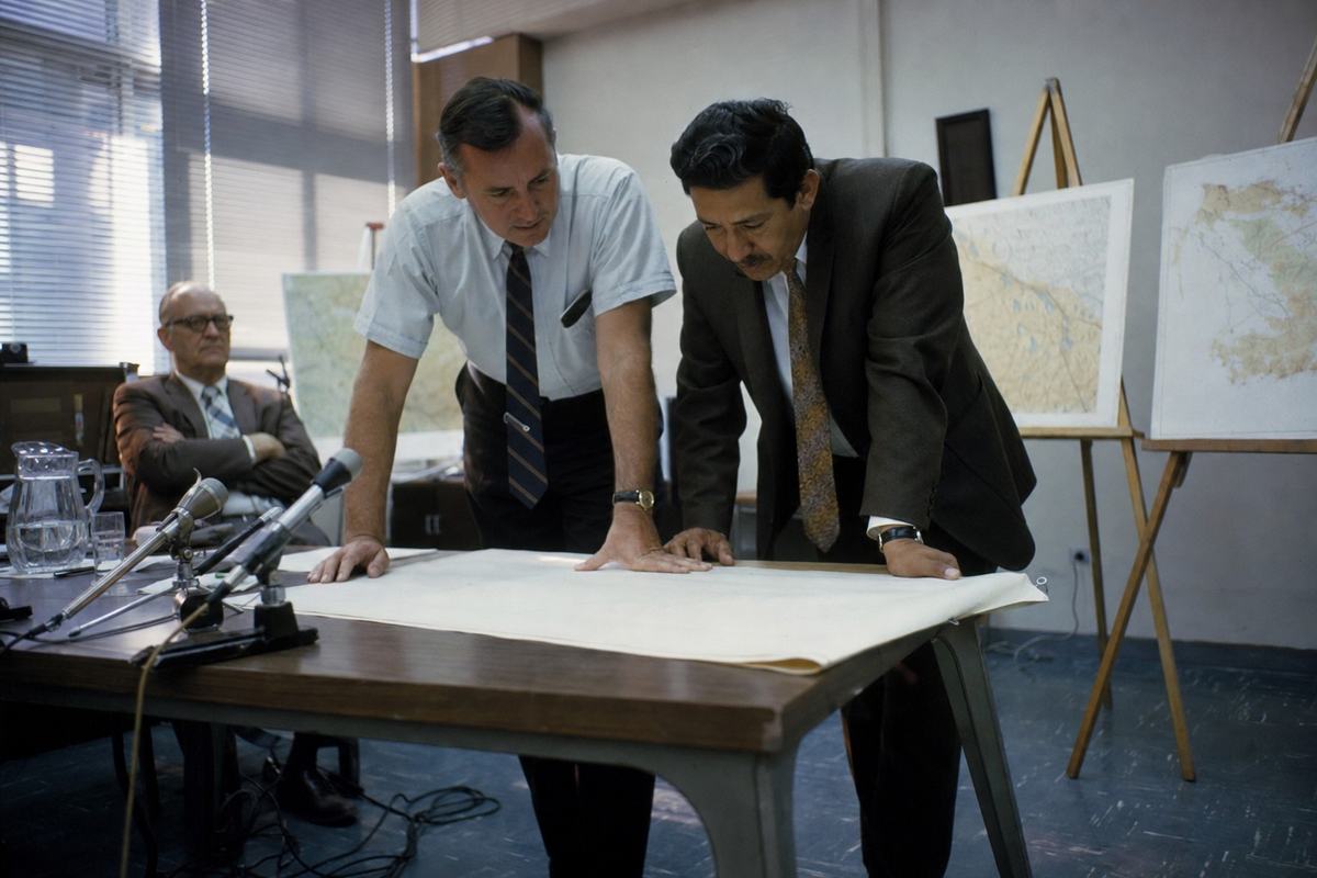 U.S. and Mexican officials lean over a table during an IBWC session in Mexicali in the early 1970s.