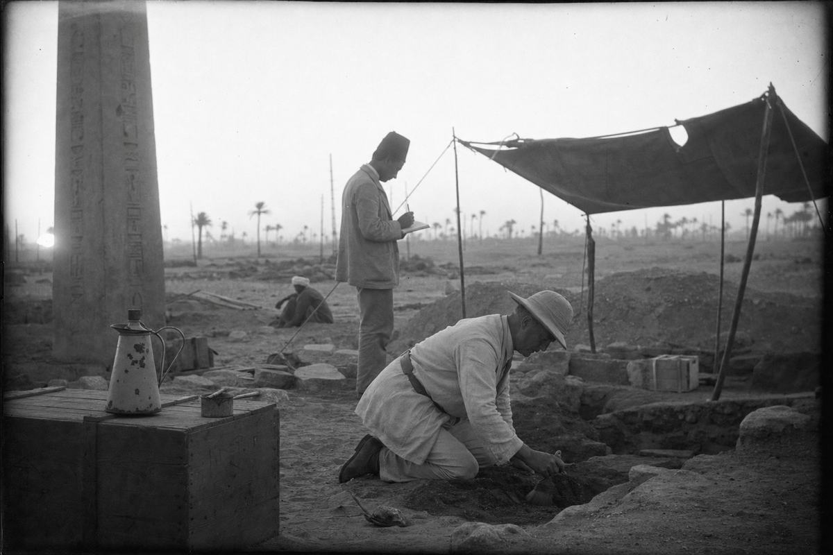 Tirage gélatino‑argentique des ruines d’Héliopolis à l’aube, archéologues au travail près d’un obélisque.