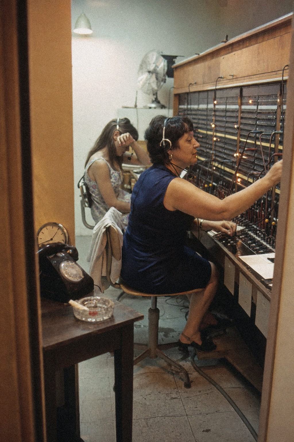 Opératrices au standard manuel du STAA, casques sur les oreilles et cordons tirés.