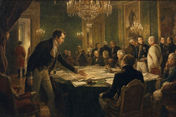Museum reproduction photograph of an early 19th-century oil painting in the Austrian academic tradition depicting the plenary of the Congress of Vienna inside a grand hall. Asymmetric composition from a slightly elevated gallery at stage-left, focusing on a single diplomat (Metternich-like figure) leaning forward with an open hand toward a cluttered central table covered with maps and folded papers; other delegates of varied ages and builds confer in small knots, some seated, some half-turned, a footman pauses near a doorway. Ornate chandeliers glow, candle sconces, gilt frames and heavy drapery, parquet floor scuffed near chair legs. Realistic brushwork with visible canvas weave, warm varnish yellowing, fine craquelure in lighter passages; no text or lettering anywhere. Captured with a 1960s copy stand setup under soft museum lights, slight edge falloff and faint glare along the lower left, preserving paint texture and surface depth.