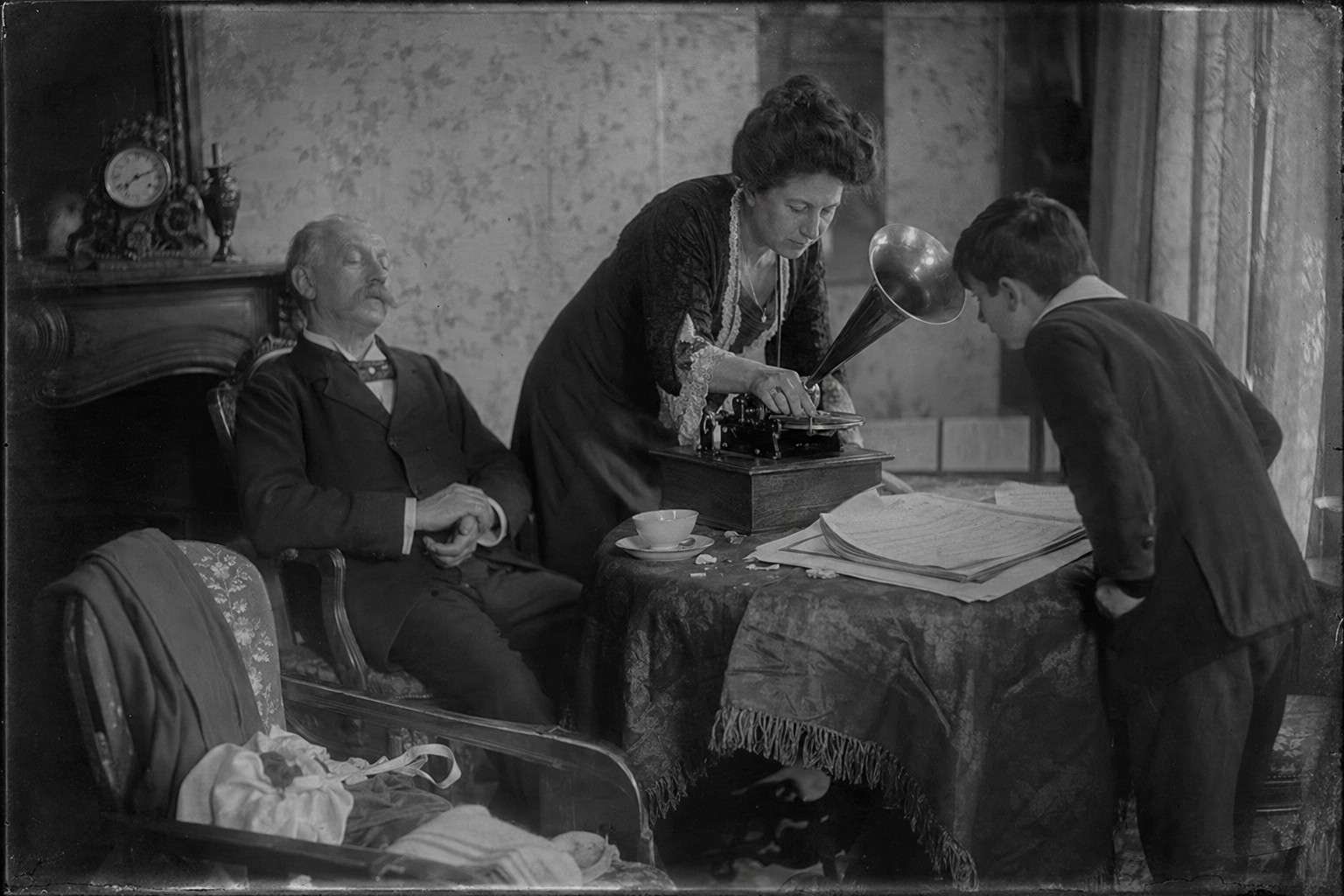 Salon parisien Belle Époque avec un appareil Pathé-Cros en fonctionnement, auditeurs réunis autour du pavillon.